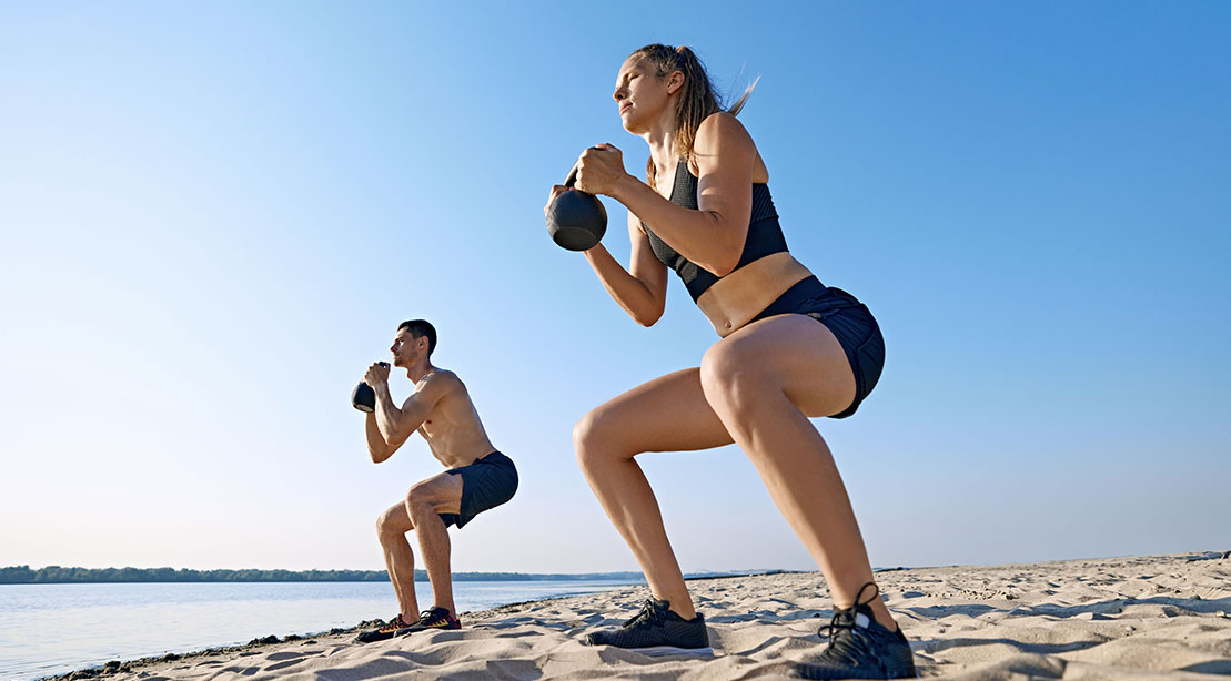 Fit and athletic couple workout with the 6 week shummer shred program on the beach
